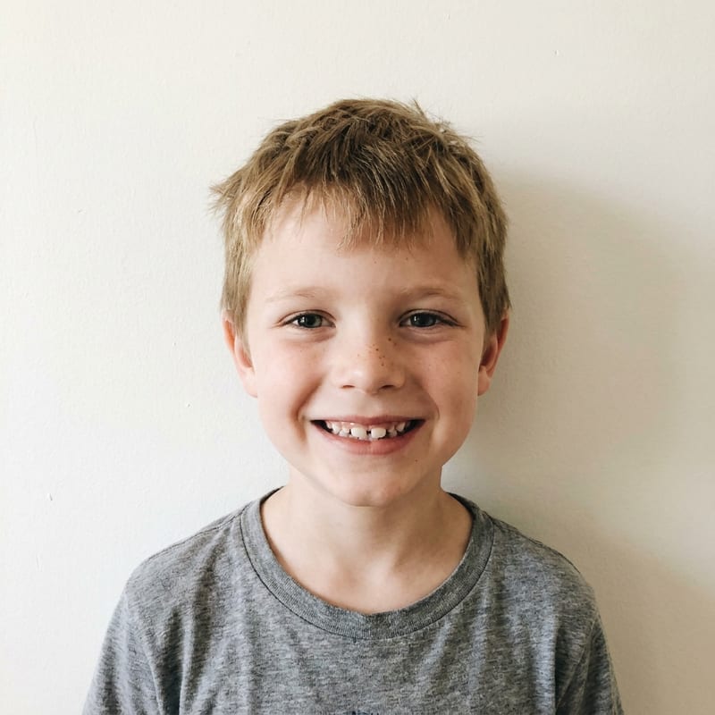 The reference photo: a smiling boy in a grey t-shirt